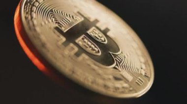 Siyah arka planda dönen altın bitcoin 'in yakın plan görüntüsü. Elektronik şifreleme sanal para. Modern teknolojiyi engelleyin. P2P bitcoin ağı. BTC logosu. Madencilik ve yatırım kavramı.