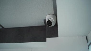 Ofis binasının tavanında asılı duran kameranın yakın çekim görüntüsü. Modern izleme ve izleme teknolojileri. Güvenlik sistemi, video izleme ve gizlilik kavramı.