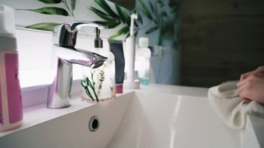 Lavaboya gelip yüzünü soğuk suyla yıkayan genç ve güzel bir kız. Çekici bir genç sabah aynanın karşısında duruyor. Banyo sabahı rutini. Yaşam tarzı kavramı.