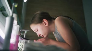 Sevimli genç kız banyoya gelir, yüzünü soğuk suyla yıkar ve aynaya bakar. Yumuşak yüzlü güzel bir kız lavabonun yanında durur, yüzünü havluyla siler. Banyo sabahı rutini.