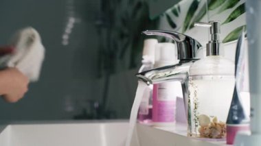 Lavaboya gelip yüzünü soğuk suyla yıkayan genç bir kız. Güzel bir genç sabah aynanın karşısına geçer ve ağzını çalkalar. Banyo rutini. Yaşam tarzı kavramı.