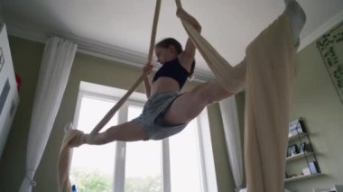 Genç kız evdeki hava jimnastiği egzersizlerini telefonla kaydediyor. Gençler açık yatak odasının ortasındaki havadan jimnastik kurdelelerinde dönüyorlar. Çekici gençlik trenleri ve hafta sonunu evde geçiriyor..