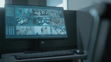 Ofisin girişinde PC olan güvenlik görevlileri için bir iş yeri. Bilgisayar monitörü güvenlik kameralarından alınan kamera görüntülerini gösteriyor. Telsiz masanın üzerinde duruyor. İzleme konsepti.
