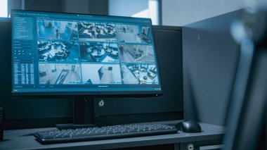 Ofisin girişinde PC olan güvenlik görevlileri için bir iş yeri. Bilgisayar monitörü güvenlik kameralarından alınan kamera görüntülerini gösteriyor. Telsiz masanın üzerinde duruyor. İzleme konsepti.
