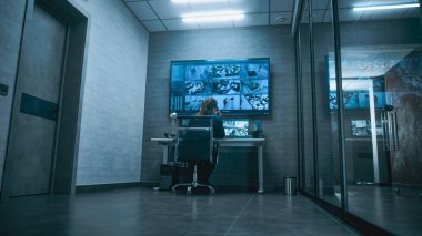 Kadın CCTV operatörünün bilgisayardaki güvenlik kameralarını izlediğini sabit telefondan konuştuğunu gördüm. Birden fazla monitör ve dijital ekrandaki güvenlik kamerası görüntüleri.