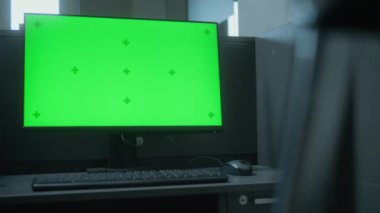 Ofisin girişinde PC olan güvenlik görevlileri için bir iş yeri. Bilgisayar monitörü yeşil ekran kromaanahtarı gösteriyor. Telsiz masanın üzerinde duruyor. Gözetim sistemi ve izleme konsepti.