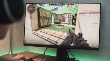 ZAPORIZHYA, UKRAINE - 7 Haziran 2024: Counter Strike 2 Gameplay on PC. Kulaklıklı profesyonel genç oyuncu eSports turnuvası sırasında bilgisayarda oyun oynuyor. Taktik birinci şahıs nişancı