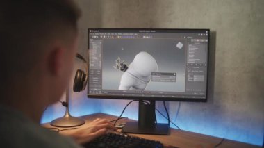 PC 'de oyun karakterinin modelini yapan beyaz bir ergen. Profesyonel 3D modelleme programının arayüzü. Genç 3D tasarımcı evde bilgisayar üzerinde çalışıyor. Oyun geliştirme kavramı.