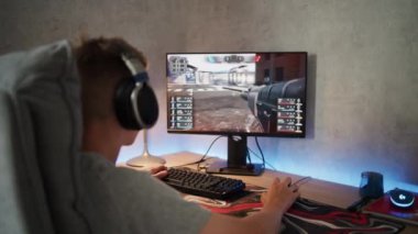 Kulaklık takan beyaz bir genç internette video oyunu oynuyor, boş zamanlarını evde geçiriyor. Profesyonel genç oyuncu bilgisayarda üç boyutlu birinci şahıs nişancı oyunlarından hoşlanır. Oyun ve Spor.