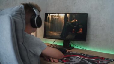 Kulaklıklı beyaz bir genç odada masada otururken internetten kavga ederek aksiyon filmi izliyor. Ergen çocuk dinleniyor ve hafta sonunu evde geçiriyor. Yaşam tarzı kavramı.
