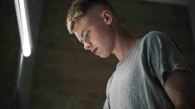 Beyaz çocuk lavaboya gelir, yüzünü soğuk suyla yıkar ve aynadaki yansımasına bakar. Genç, havzanın önünde duruyor ve sabah banyolarını rutin hale getiriyor. Yaşam tarzı kavramı.