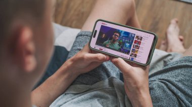 Akıllı telefon ekranında gösterilen renk düzeltmesiyle ilgili blog içeriğiyle video paylaşım platformu. Genç kızların cep telefonlarında renk derecelendirme videolarını izleyip kanepede oturmalarına yakın çekim yapmak..