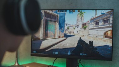 ZAPORIZHYA, UKRAINE - 7 Haziran 2024: Counter Strike 2 Gameplay on PC. Kulaklıklı profesyonel genç oyuncu eSports turnuvası sırasında bilgisayarda oyun oynuyor. Taktik birinci şahıs nişancı