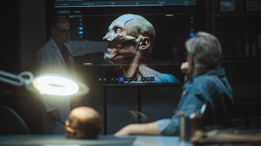 Kıdemli bilim adamı ayağa kalkar ve ekranda antik insan kafasının 3 boyutlu görüntüsünü gösterir. İki arkeolog fosil kafatası üzerinde çalışıyor, geceleri ileri arkeoloji laboratuvarında tarihi araştırmalar yapıyorlar..