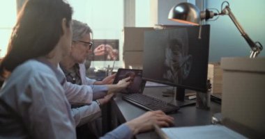 PC ve tablet bilgisayar ekranlarında gösterilen antik insan kafası anatomisinin 3 boyutlu görselleştirilmesini tartışan iki farklı bilimadamı, tarihi araştırmalar yürütüyor. Arkeologlar arkeoloji laboratuvarında çalışırlar..