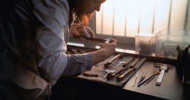 Kadın bilim adamı ya da arkeolog, alet kullanarak kemikleri ölçer, antik insan veya dinozor iskeletinin kalıntılarını inceler. Gelişmiş arkeoloji laboratuvarında fosil numune koleksiyonu. Gün batımı ışığı. Yavaş Hareket