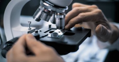 Mikrobiyolog ya da kimyager fosil numunelerini analiz için mikroskop altına alıyor. Bilim adamı veya arkeolog ileri arkeoloji laboratuvarında profesyonel ekipmanlarla çalışıyor..