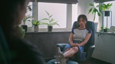 Depresyondaki Afrikalı Amerikalı bir kız sandalyede oturur, kadın psikoterapist veya psikologla aile sorunlarını tartışır. Genç hasta terapi seansında zihinsel sorunlardan bahsediyor. Psikoloji konsepti.
