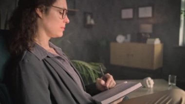 Psikoloji Ofisi: Kadın psikolog not defterine not alır, genç hastaları dinler. Afrikalı Amerikalı genç kız psikoterapistle terapi seansı sırasında sorunları tartışıyor..