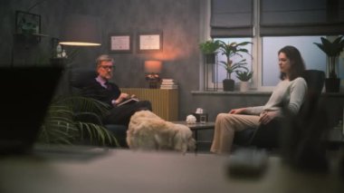 Olgun psikolog kadın hastalarla konuşur, psikoterapi sağlar. Yetişkin bir kadın sandalyede oturur terapi seansı sırasında terapistle sorunları tartışır. Golden Retriever köpeği. Ruh Sağlığı.