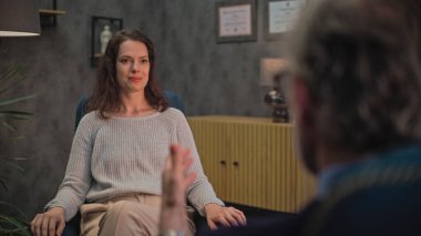 Pozitif kadın sandalyede oturur, psikoterapistle konuşur, terapi sırasında psikoterapide çözüm bulur. Psikologla terapi seansında olan bir kadın hasta. Psikoloji ve akıl sağlığı.