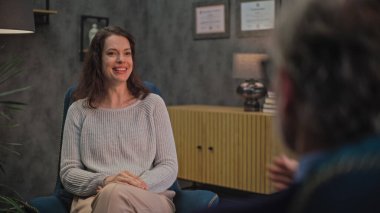 Pozitif kadın sandalyede oturur, psikoterapistle konuşur, terapi sırasında psikoterapide çözüm bulur. Psikologla terapi seansında olan bir kadın hasta. Psikoloji ve akıl sağlığı.