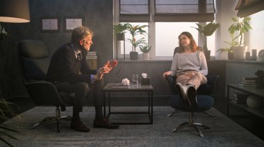 Üzgün ve stresli bir kadın terapistle terapi seansı sırasında psikolojik travmayı tartışıyor. Olgun psikolog kadın hastalarla konuşur, sorular sorar, psikoterapi sağlar. Ruh Sağlığı.