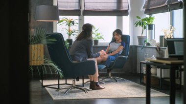 Psikoloji Ofisi: Üzgün Afrikalı Amerikalı kız psikoterapistle terapi seansı sırasında sorunları tartışıyor. Kadın psikolog not alır, genç hastaları dinler. Yavaş Hareket.