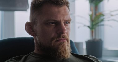 Travma sonrası stres bozukluğu olan, depresif ve stresli bir askerin kameraya doğru ağır ağır nefes alışını kapatın. Rehabilitasyon, psikoterapist veya psikologla terapi seansı. PTSD.