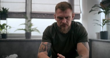 Şok olmuş yaralı bir asker ya da sandalyede oturup ağlayan bir travma sonrası stres bozukluğu. Psikolojik rehabilitasyon ya da psikologla terapi seansı sırasında asker. Travma sonrası stres bozukluğu..