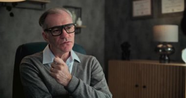 Gözlüklü kıdemli psikoterapist sandalyeye oturur, hastaları dinler ve psikolojik rehabilitasyon sırasında sorular sorar. Profesyonel askeri psikolog terapi seansı düzenliyor. Ruh Sağlığı.