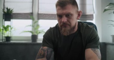 Şok olmuş yaralı bir asker ya da sandalyede oturup ağlayan bir travma sonrası stres bozukluğu. Psikolojik rehabilitasyon ya da psikologla terapi seansı sırasında asker. Travma sonrası stres bozukluğu..