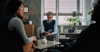 Çok ırklı çiftlerin sandalyelerde oturup, ilişki sorunlarını tartışmaları, çözüm bulmaları ve çiftler terapi seanslarında uzlaşmaları. Olgun terapist genç aileyi dinler, notlar alır..