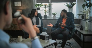 Terapistin terapi seansında genç bir aileyi dinlediğini gördüm. Çok ırklı çiftler sandalyeye oturur, evlilik ve ilişki sorunlarını tartışır, çiftler terapisi için kavga etmeye başlarlar. Psikoloji konsepti.