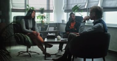 Asyalı bir kadın sandalyede oturup terapi seansı sırasında erkek arkadaşıyla ilişkisi hakkında psikologla konuşur. Olgun psikoterapist, çok ırklı genç bir aileyi dinler, çift terapisi sağlar..