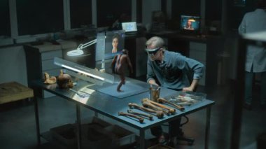 Gelişmiş arkeoloji laboratuvarı: VR kulaklık uzmanı arkeolog yapay zeka simülatöründe antik insan evrimini araştırıyor, artırılmış gerçekliği kullanarak araştırma yapıyor. Yapay zeka asistanıyla birlikte üç boyutlu sanal görüntü oluşturma. VFX