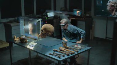 Gelişmiş arkeoloji laboratuvarı: VR kulaklık alanında arkeolog fosil kafatası ve antik insan anatomisini artırılmış gerçeklik kullanarak inceliyor. Yapay zeka asistanı ve web tarayıcısıyla üç boyutlu sanal görüntü grafikleri. VFX