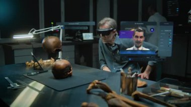 Gelişmiş arkeoloji laboratuvarı: VR kulaklık alanında arkeolog fosil kafatası kullanarak artırılmış gerçeklik üzerinde bilimsel araştırmalar yürütüyor. Yapay zeka asistanı ve web tarayıcısıyla sanal ekranın 3 boyutlu animasyonu. VFX