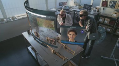 Gelişmiş arkeoloji laboratuvarı: VR kulaklıklarda çalışan iki arkeolog iskelet üzerinde çalışmalar yapıyor ve geliştirilmiş gerçeklik kullanıyor. Yapay zeka ses asistanı ve bilgi web tarayıcısıyla üç boyutlu sanal görüntü canlandırması.