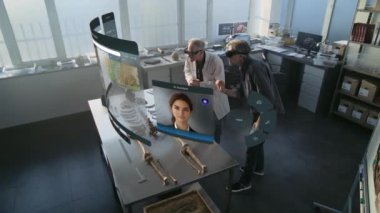 Gelişmiş arkeoloji laboratuvarı: VR kulaklıklarda çalışan iki arkeolog iskelet üzerinde çalışmalar yapıyor ve geliştirilmiş gerçeklik kullanıyor. Yapay zeka ses asistanı ve bilgi web tarayıcısıyla üç boyutlu sanal görüntü canlandırması.