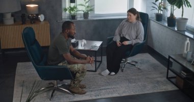Travma sonrası stres bozukluğu olan Afrika kökenli Amerikalı bir askerin terapi sırasında psikologla konuşması. Kadın terapist, terapi seansında hastayı dinler. Travma sonrası stres bozukluğu.