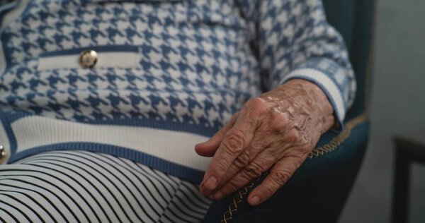 Close up of elderly patients hand during therapy session. Woman sitting in chair discussing psychological problems and mental trauma in therapy session Psychology concept. Psychotherapy for elderly.