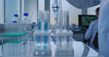 Gelişmiş tıbbi araştırma laboratuvarı: Eldiven giyen profesyonel bilim adamı pipet kullanıyor, analiz için test tüplerine cam şişeden sıvı döküyor. Bilimsel Laboratuvarda çalışıyorum. Uyuşturucu geliştirme. Kapat..