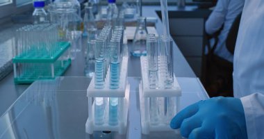 Tıbbi bilim laboratuvarı: Kimyager ya da bilim adamının analiz için pipetli test tüplerine mavi sıvı koyması. Biyoteknoloji deneyi. Gelişmiş farmakoloji laboratuvarı. Bilimsel yöntem.
