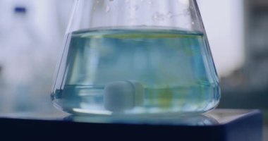 Modern ekipmanlara sahip tıp bilimi laboratuvarı: bilim adamı ve kimyager cam şişeye sıvı döker. Dönen manyetik karıştırıcıyı kapat, sıvı maddeleri karıştır. Bilimsel yöntem. Yüksek teknoloji laboratuvar aygıtı