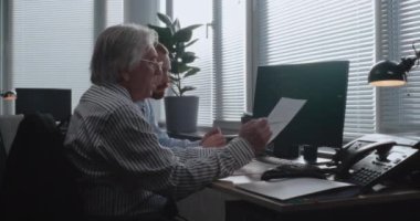 Modern ofiste: Şirket ortakları sermaye piyasasını ve bilgisayar hisselerini izler, stratejiyi tartışır, belgeleri ve belgeleri analiz ederler. Uluslararası şirkette iki profesyonel finans tüccarı.
