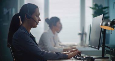 Çağrı merkezi: Kafkas yardım hattı operatörünün portresi müşteriyle kulaklıkla konuşuyor, bilgisayarla çalışıyor, müşteriye çevrimiçi yardım sağlıyor. Teknik destek uzmanlarından oluşan bir ekip.