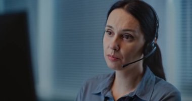 Psikolojik yardım hattının modern çağrı merkezi: Kafkas kadın yardım hattı operatörünün portresi kulaklıkla konuşuyor, internetten danışmanlık yapıyor, zihinsel sağlık yardımı sağlıyor. Duygusal destek kavramı