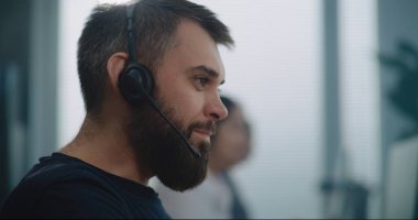 Modern çağrı merkezi: Beyaz tenli teknik destek uzmanının portresi, çağrı anında müşteriyle iletişim kurma ve çevrimiçi yardım sağlama konusunda yakından inceleniyor. Müşteri tecrübesi memuru.