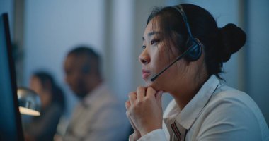 Ruh sağlığı hattının modern çağrı merkezi: Asya yardım hattının kulaklık dinleme uzmanı portresini kapatın, çevrimiçi danışmanlık, psikolojik destek ve duygusal destek sağlama.
